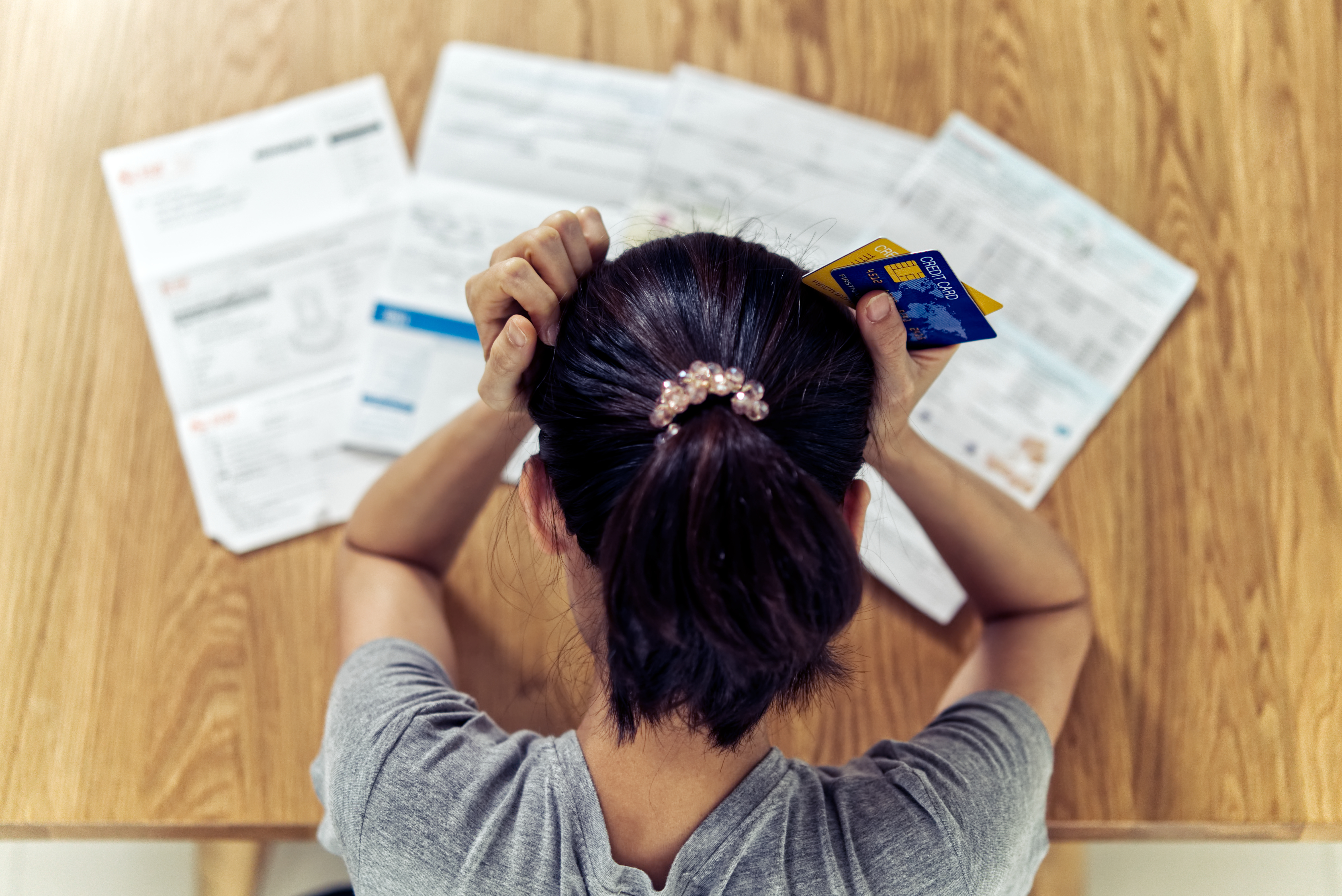 Top view of stressed young woman with credit cards Top view of stressed young woman with credit cards