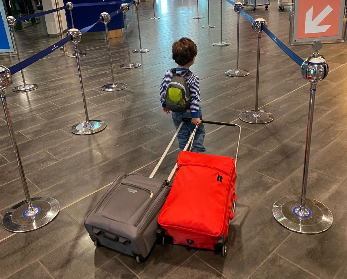 Toddler Travel Kid with suitcases in airport