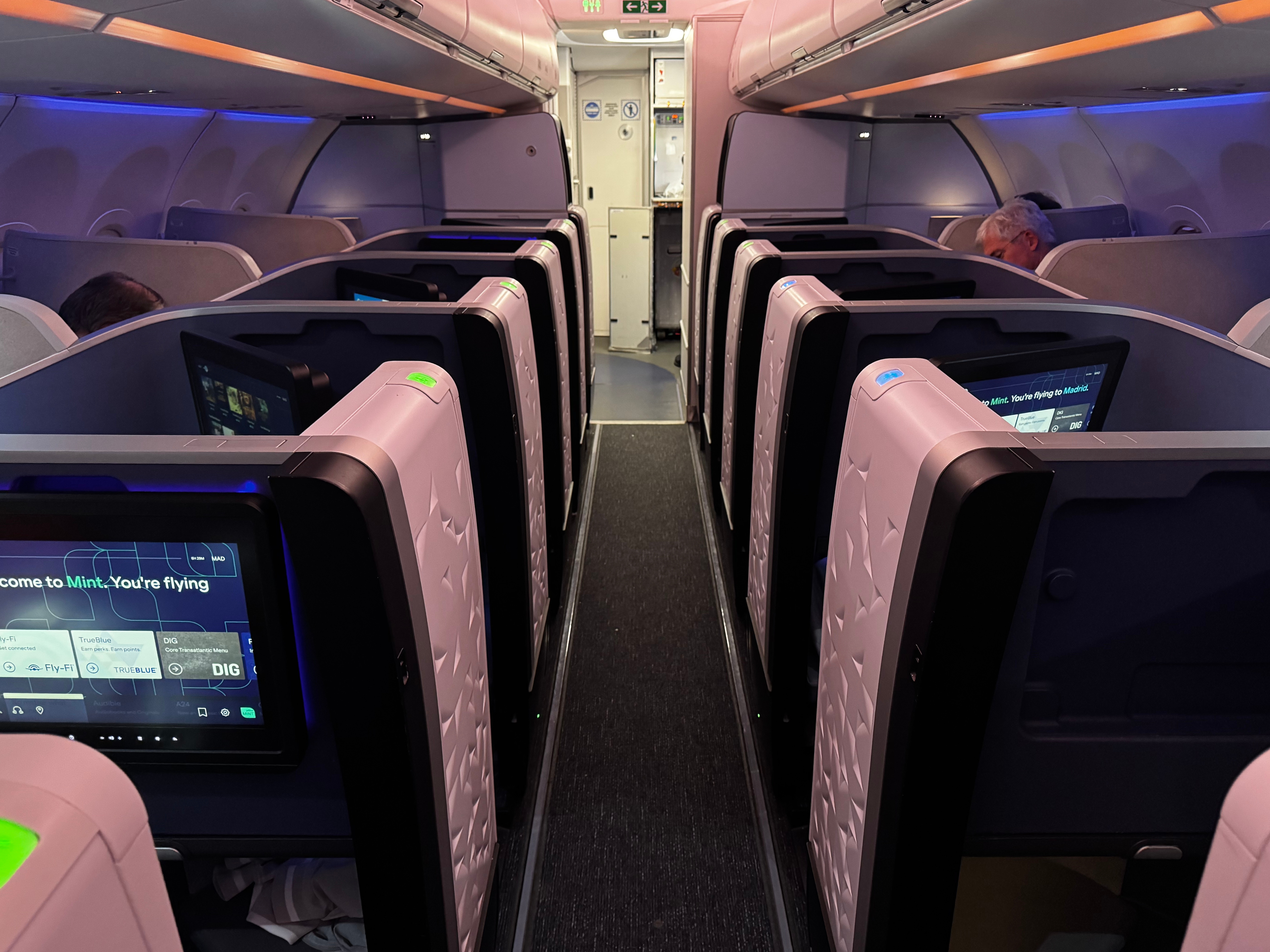 JetBlue Mint A321XLR BOS MAD view up aisle lit JetBlue Mint A321XLR BOS MAD view up aisle lit