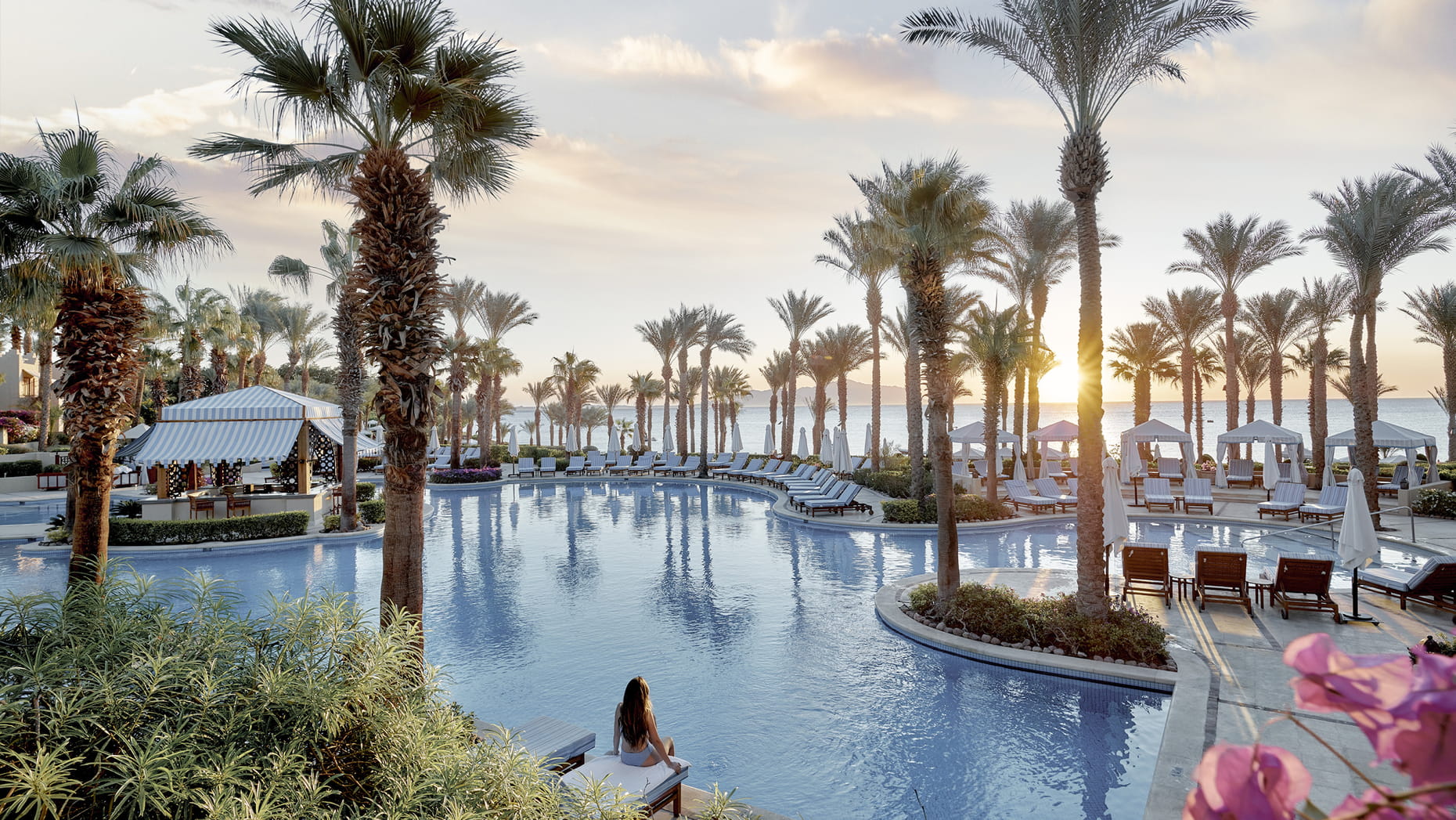 Four Seasons Sharm El Sheikh pool Pool, palm trees, and sunset over the sea