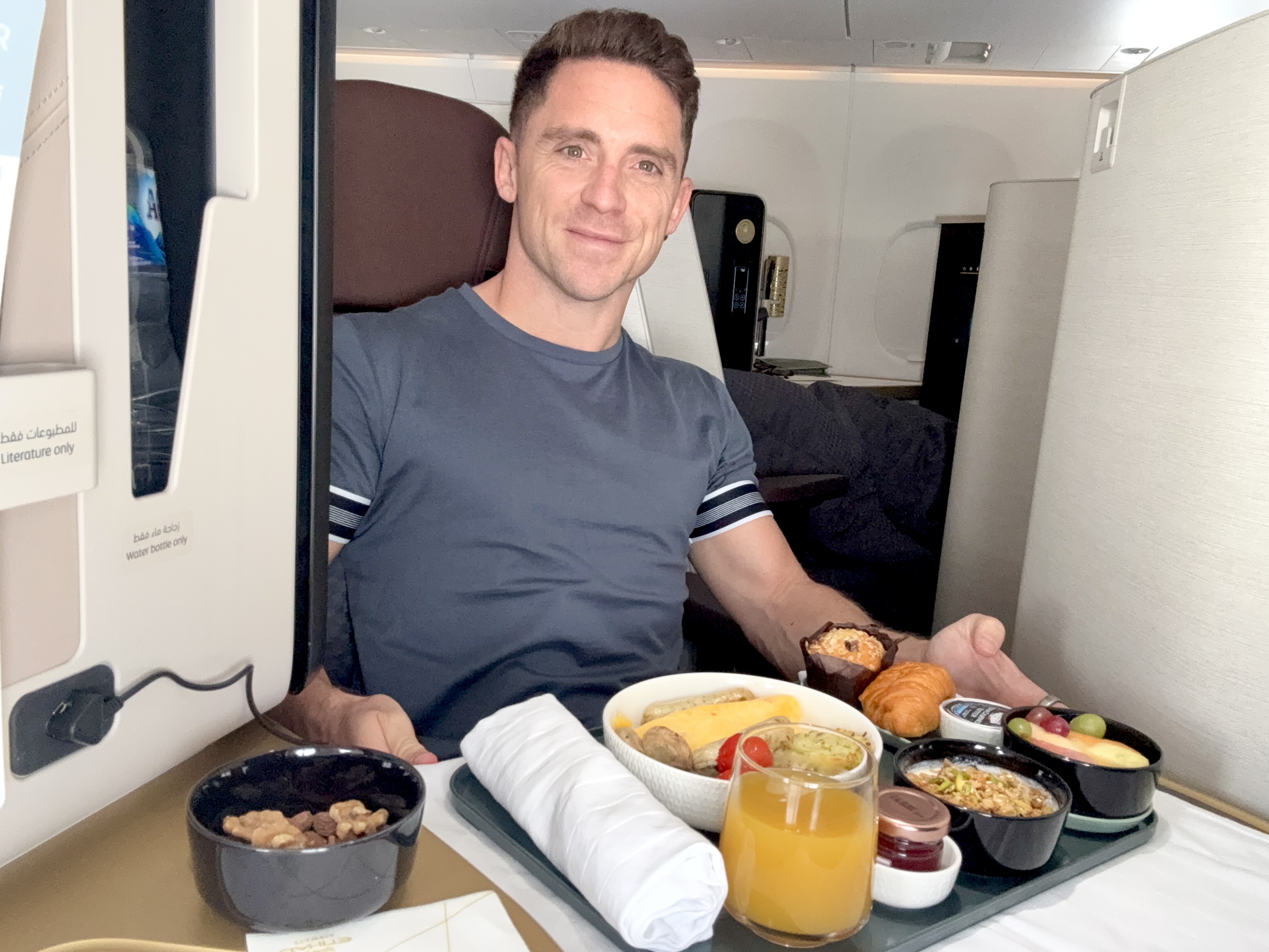 Daniel enjoying Etihad business class breakfast on an Airbus A321LR